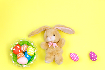 Easter concept. Easter bunny decorative with eggs on yellow background. top view, copy space.E aster Flat lay. S