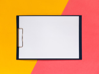 Creative geometric flat lay background. Blank clip board, yellow and pink color paper. Minimalistic...