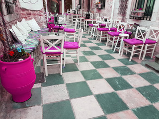 Fototapeta na wymiar street cafe colors tables chairs pillows in Ioannina city greece