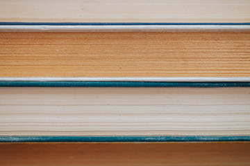 Vintage books close-up. Stack of used old literature in school library. Background from old chaotic reading matter. Dusty faded books horizontally with copy space. Old book store.