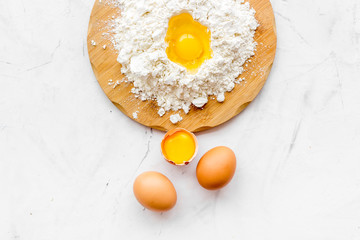 Making dough concept. Pile of flour and eggs on white background top view space for text