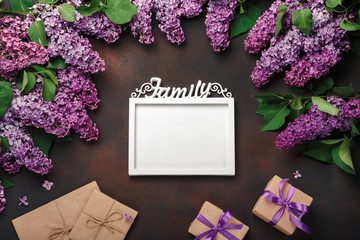 A bouquet of lilacs with a white frame for inscription, gift box, craft envelope, a love note on...