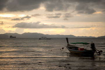 Naklejka na ściany i meble Beautiful sunset on the sea with traditional thai fishing longtail boats