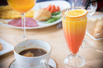 A restaurant food. A drink with orange on top of the glass. A light dish on a plate