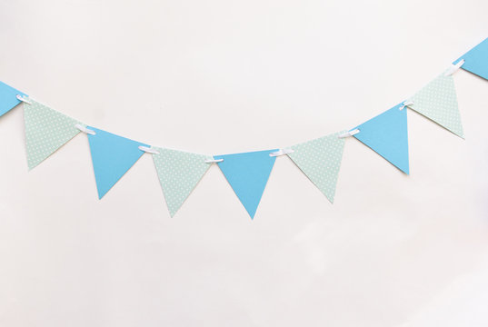 Festive Decor For A Children's Holiday To Smash The Cake Or A Birthday, Baby Shower Boy. Blue Triangular Flags On White Wall