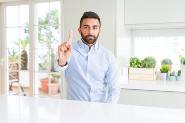 Handsome hispanic business man Pointing with finger up and angry expression