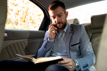 Businessman holding a phone and reading the notes