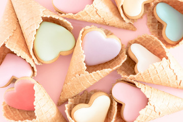 Valentine's day background. Ice cream waffle cone with ginger cookie in shape heart on pink...