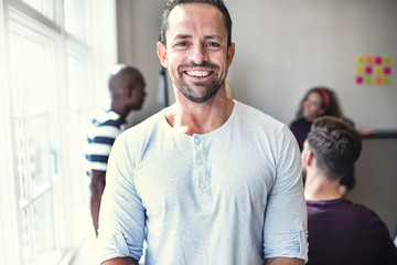 Fototapeta premium Designer smiling while standing in a bright office