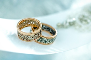 Two wedding rings with rare design on white broad ribbon