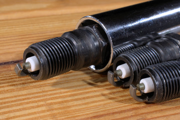 closeup of spark plugs on wood background