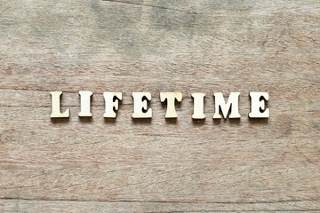 Letter block in word life time on wood background