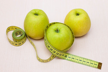 Apples and measuring tape on the table. Diet, proper nutrition