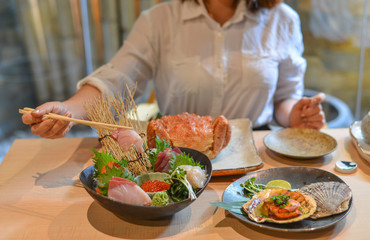 Woman eating and enjoying Japanese meal