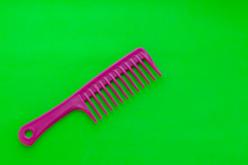 Beauty shop. Hairdresser's tools. Comb on bright green background. Сopy space.