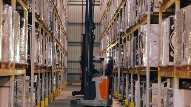 Large modern warehouse, forklift transports the box. Workflow in a warehouse with boxes
