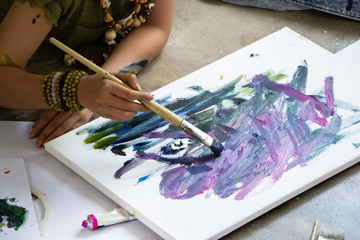 Fototapeta premium Hand of young artist painting on canvas,doing art work,at studio