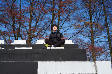 mały chłopak w czarnej kurtce ćwiczy joga  © ftomasz