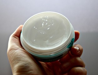 hand palm hand cream jar cream in hand thick white box tasty face food sweetness beauty industry wrinkles personal care brush fingers woman tenderness used manicure female hand cover green health text