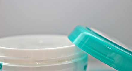 hand palm hand cream jar cream in hand thick white box tasty face food sweetness beauty industry wrinkles self-care brush fingers woman tenderness used manicure female hand cover green