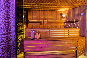 Obraz na płótnie Canvas Interior of wooden finnish sauna with birch broom, bucket and stove. The Finnish sauna is a substantial part of their culture