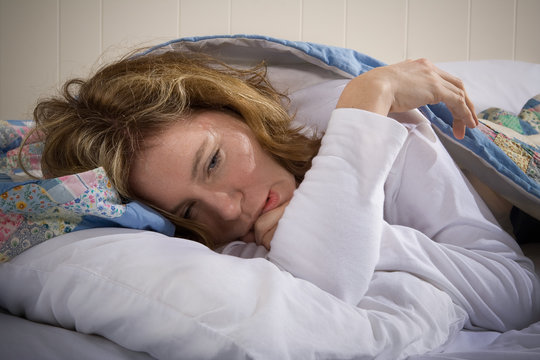 Sick Depressed or Worried Woman awake in Bed
