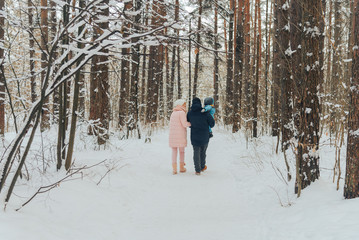 Walking family with a child. Family walks in nature in winter. Winter family walk in nature. A lot of snow.