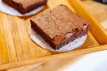 Fototapeta na wymiar Close up Square Brownie Chocolate Cakes on wooden tray that ready to sell. Melt in your mouth.