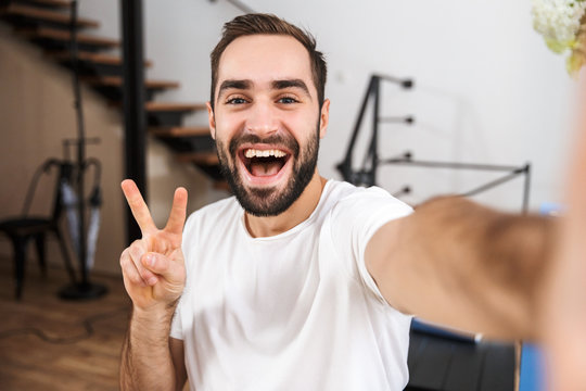 Happy Man Taking A Selfie While Sitting At The Kitchen