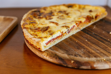 Bacon and Cheese Quiche cut in half on wooden plate.