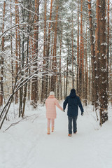 A loving couple walks in the woods. Family walk in the winter forest