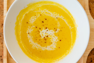 Top view close up of Classic Pureed Pumpkin Soup topping with Milk, Cream and Pepper. 