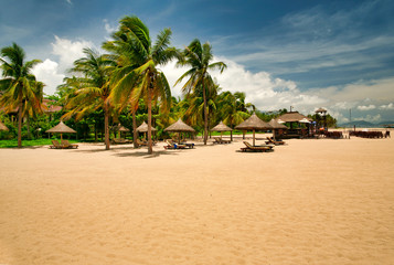 Many empty sun loungers on the deserted beach of Hainan Island.