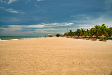 Fototapeta na wymiar Many empty sun loungers on the deserted beach of Hainan Island.