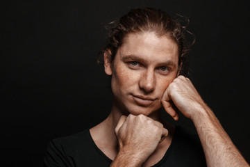 Fototapeta premium Portrait of a handsome long-haired man with drawn hair and freckles wearing a black T-shirt