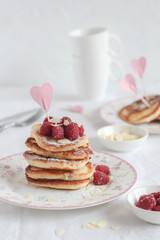 Bright mood breakfast table with a stack of pancakes and coffee cups and heart decor