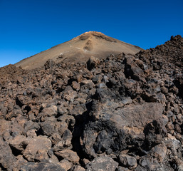 Teide volcano top crater and blue sky over the rock lava fields