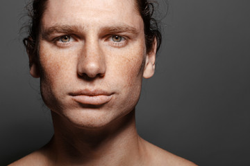 Fototapeta premium Portrait of a handsome long-haired man with drawn hair and freckles