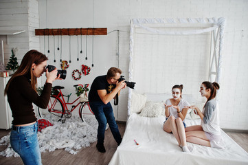 The team of two photographers shooting on studio twins girls while they make their own masks cream....