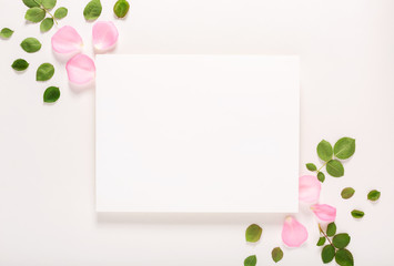 Roses and blank greeting card top view flat lay