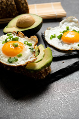 Avocado sandwich with fried egg and fresh vegetables