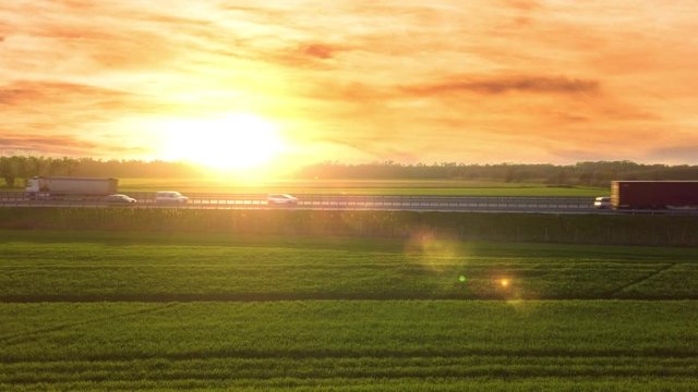 Traffico autostradale per le vacanze in Estate visto di profilo con sole giallo al tramonto.
