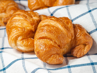 fresh croissants on checkered towel.