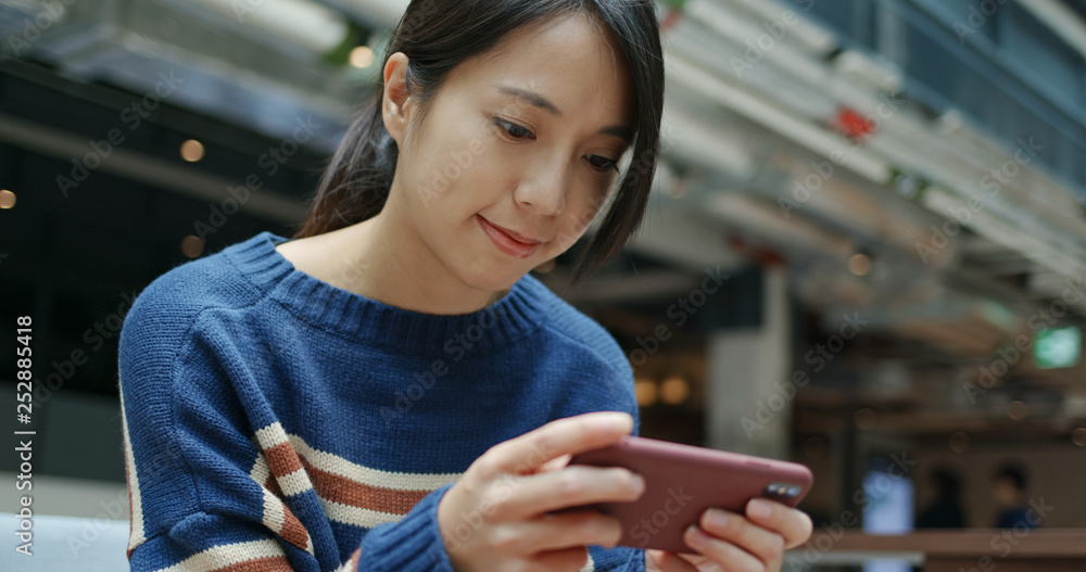 Wall mural Woman play game on cellphone