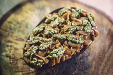 Chocolate egg with filling for Easter on wooden background.