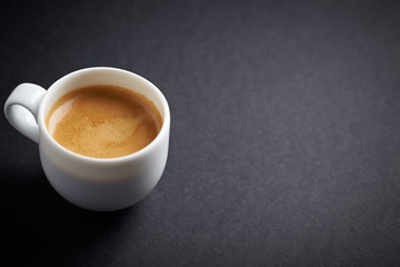 Cup of coffee on black background. Copy space.