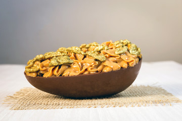 Chocolate egg with filling for Easter on wooden background.