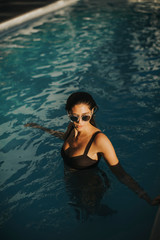 Pretty young woman in the outdoor swimming pool