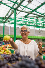 Fototapeta premium Senior woman buying apples on market