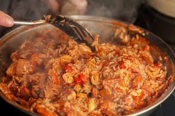 Chicken and Chorizo Jambalaya being stirred in a pan